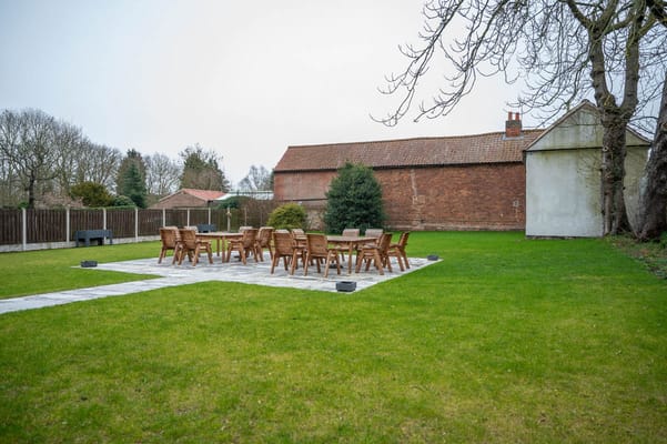 Outdoor seating area with tables and chairs on grass