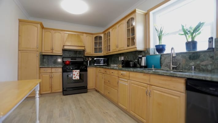 Bright kitchen area with wooden cabinets and appliances