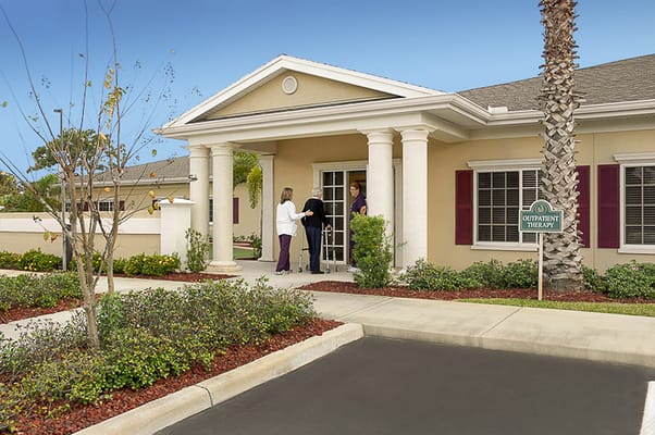 Entrance of assisted living facility with people interacting.