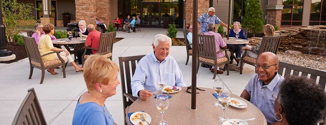 Residents enjoying a meal outdoors in a lively atmosphere