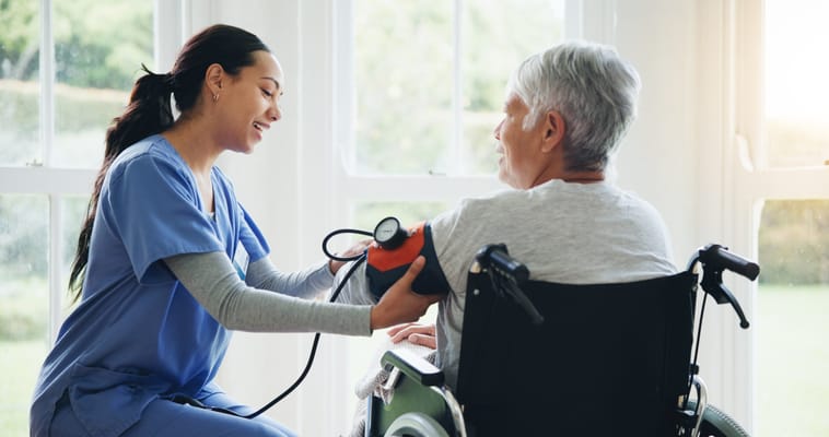 A nurse taking a blood pressure measurement of a resident