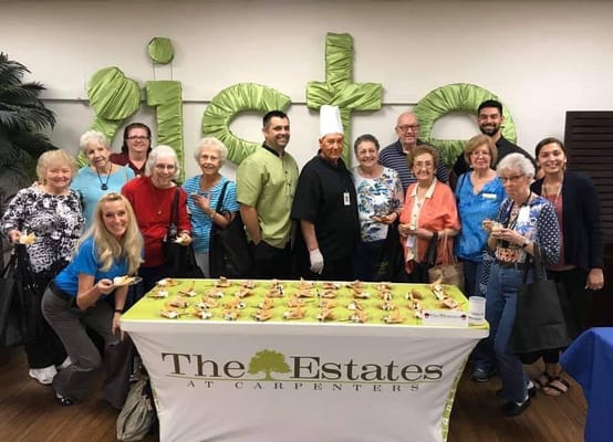 Residents and staff enjoying a food event with desserts