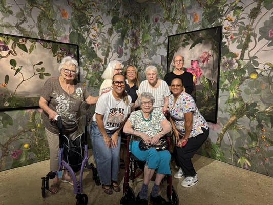 Residents and staff posing together in a vibrant indoor space