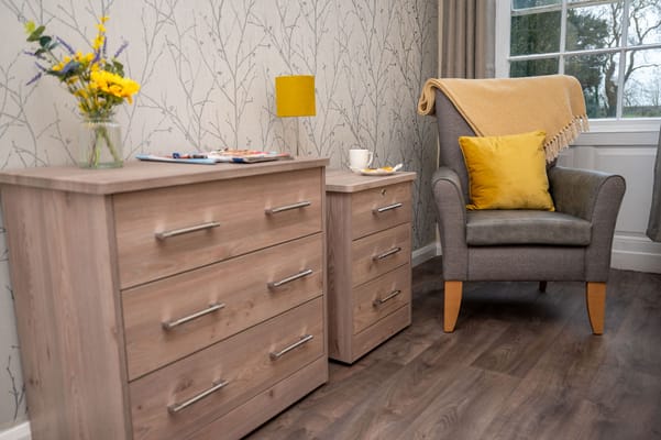 Cozy resident room interior with a chair and drawers