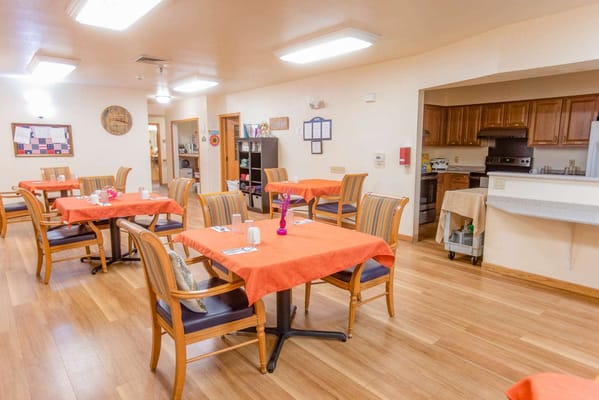 Dining area with orange tablecloths and wooden chairs
