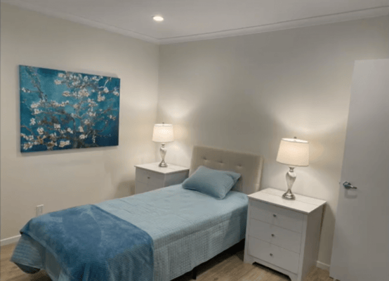 Well-furnished private resident room with a bed and lamps