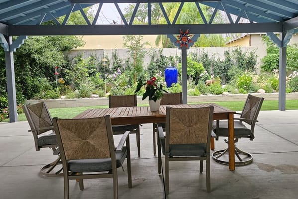 Outdoor seating area under a pergola with garden view