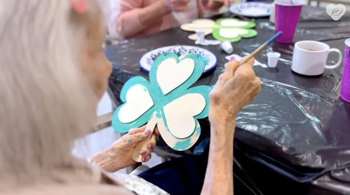 Resident painting a craft in an activity room