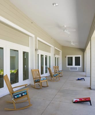 Porch area with rocking chairs and a paved walkway