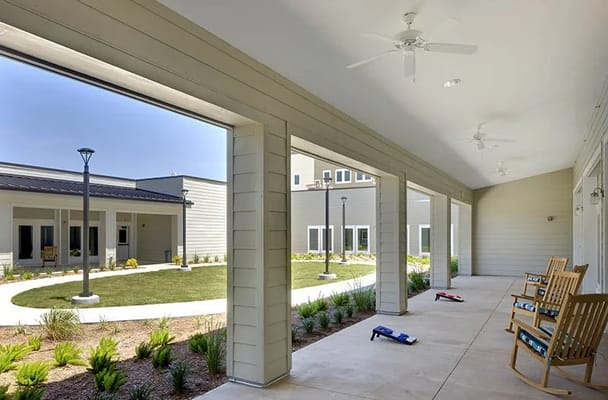 Covered porch area with rocking chairs overlooking a garden
