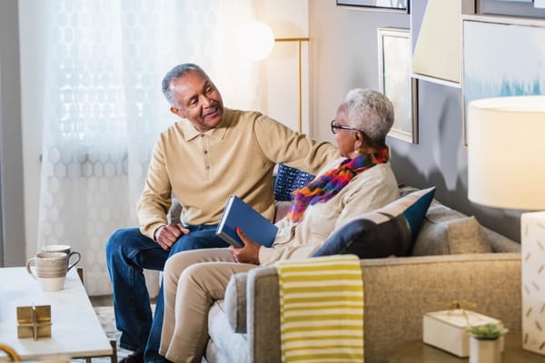 Two residents enjoying conversation in a cozy lounge area