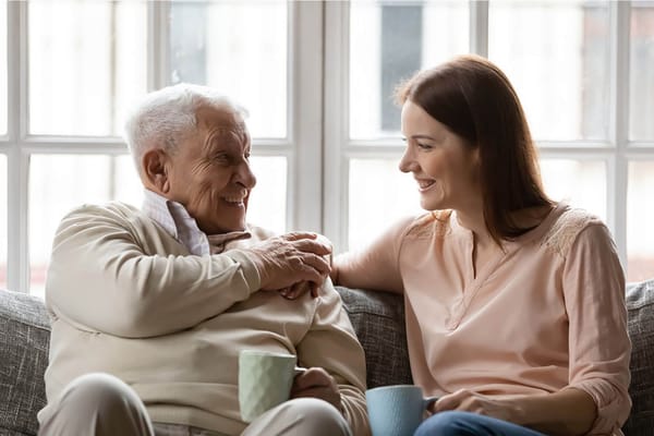 A resident and staff member enjoying tea together in a cozy lounge