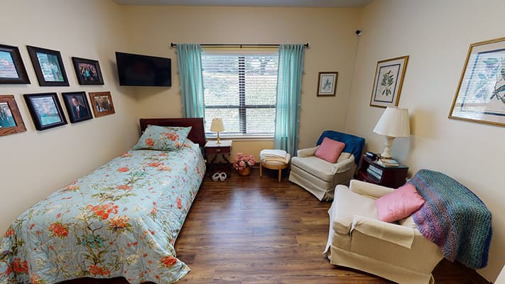 Cozy private resident room with floral bedding and seating