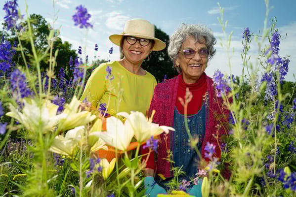 Two women enjoying gardening in a flower garden