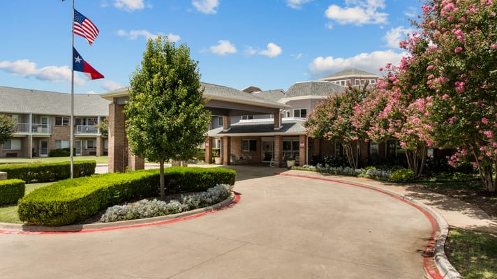 Front entrance of a senior living facility with gardens