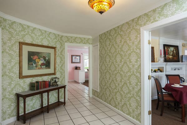 Brightly lit hallway with floral wallpaper and art