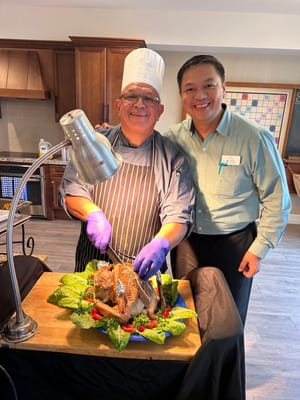 Chef serving a beautifully presented dish with a resident