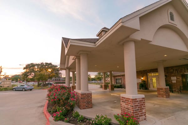 Covered entrance of a senior living facility with flowers