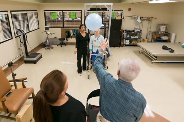 Residents participating in a therapy activity with staff guidance