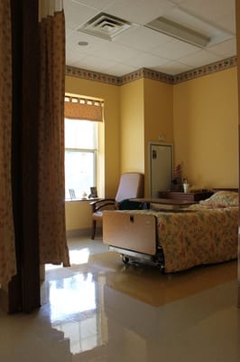 Private resident room with floral bedding and window