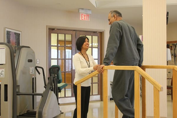 Staff assisting a resident in a rehabilitation area