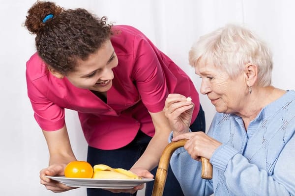 Caregiver assisting a senior with food