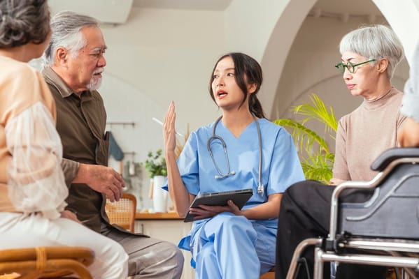 Nurse discussing with residents in a communal area