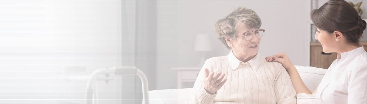 A caregiver talking with a resident in a bright room