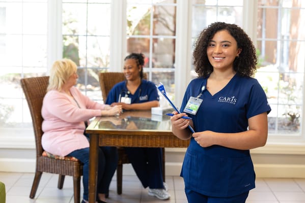 Staff member interacting with residents in a bright common area
