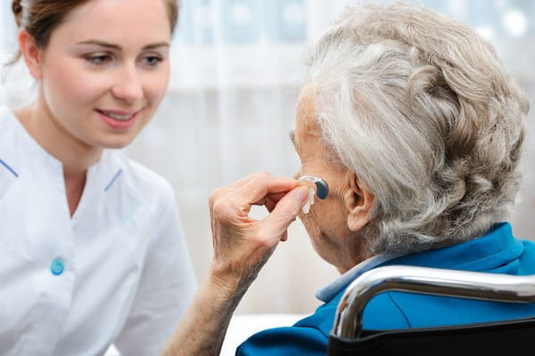 Nurse assisting an elderly resident in a bright room