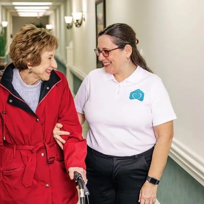 Staff member assisting a resident in a hallway