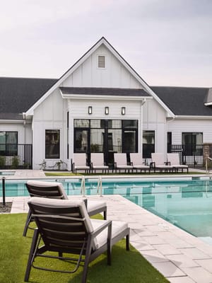 Outdoor pool area with lounge chairs and building facade