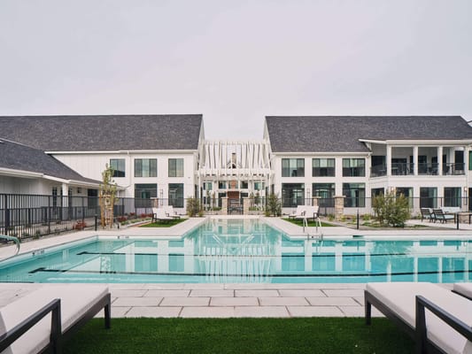 Exterior view of a modern senior living facility with a pool