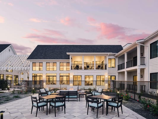 Exterior view of a senior living facility with outdoor seating
