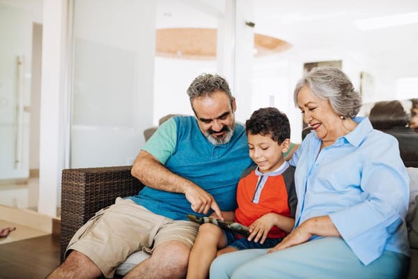 Grandparent and child engaged with a tablet in a cozy lounge
