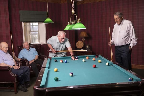 Residents playing billiards in a recreation room