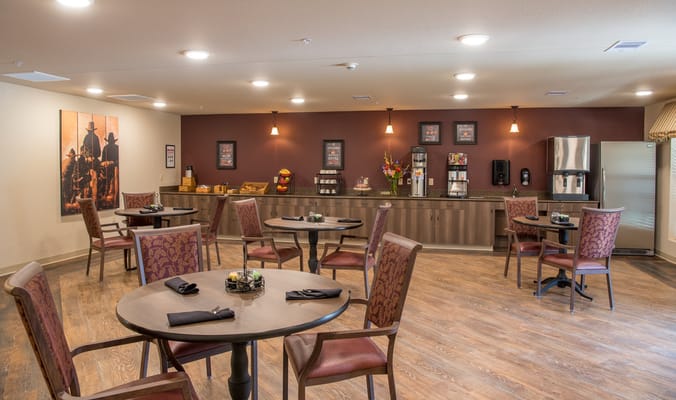 Bright dining area with tables and chairs for residents