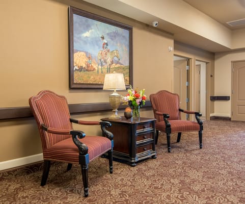 Cozy seating area in a hallway with artwork
