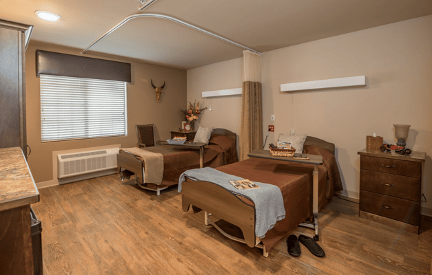 Private resident room with two beds and bedside tables