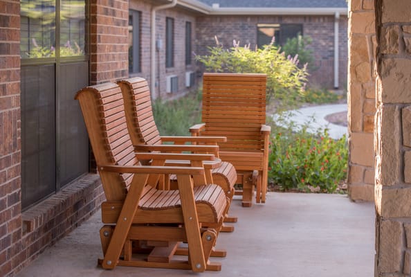 Two wooden rocking chairs on a porch