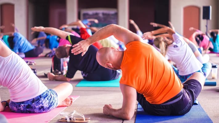 Residents participating in a yoga class in a bright common area
