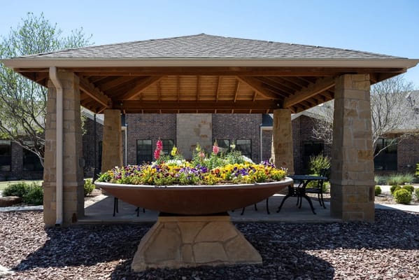 Outdoor gazebo with a flower display in a garden area