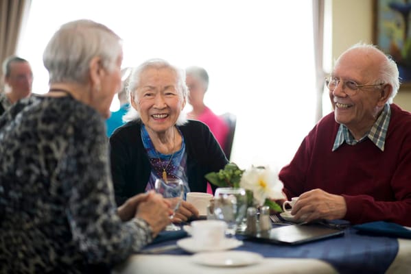 Residents enjoying a cheerful conversation at a communal table