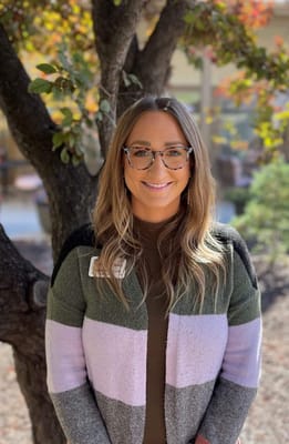 Staff member smiling outdoors in a community setting