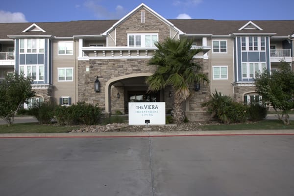 Front entrance of The Viera Senior Living facility with signage and landscaping