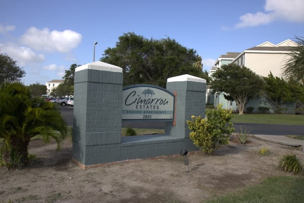 Signage for Cimarron Estates with green landscaping