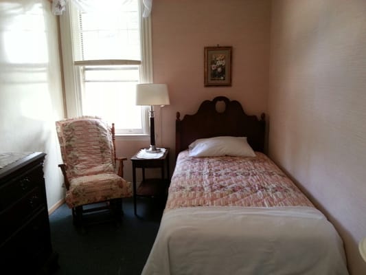 Cozy private resident room with bed and lamp