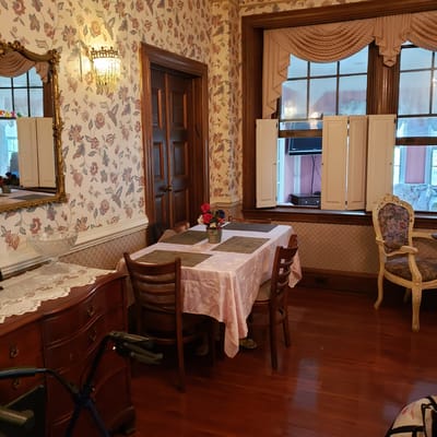 Interior view of a cozy resident room with floral wallpaper