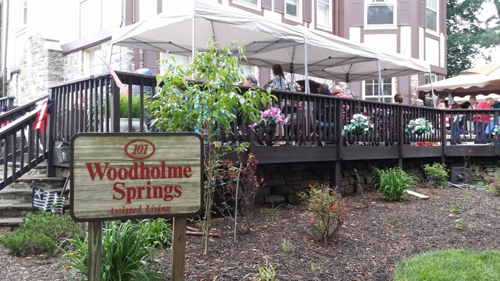 Exterior view of Woodholme Springs Assisted Living with outdoor seating
