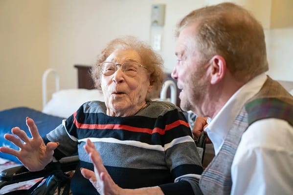 A senior resident joyfully interacting with a staff member